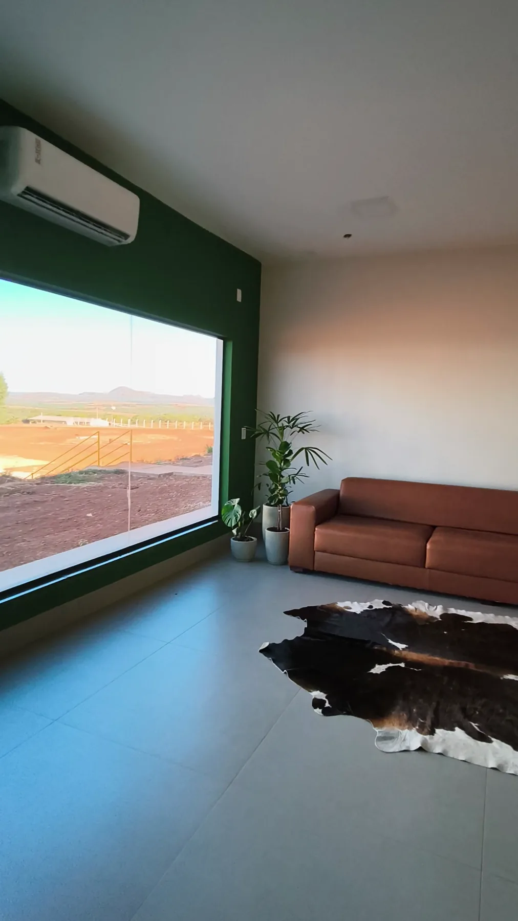 Recepção do bloco administrativo entregue, com janela panorâmica e vista do pátio