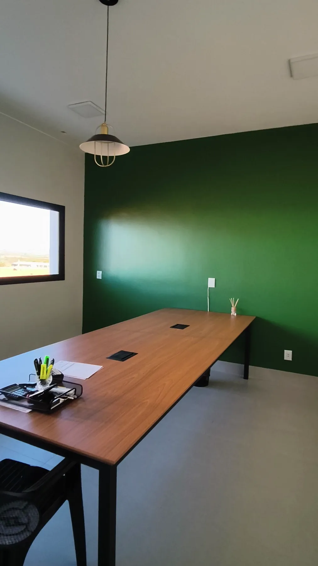 Sala de reunião com mesa ampla e ponto elétrico embutido no tampo