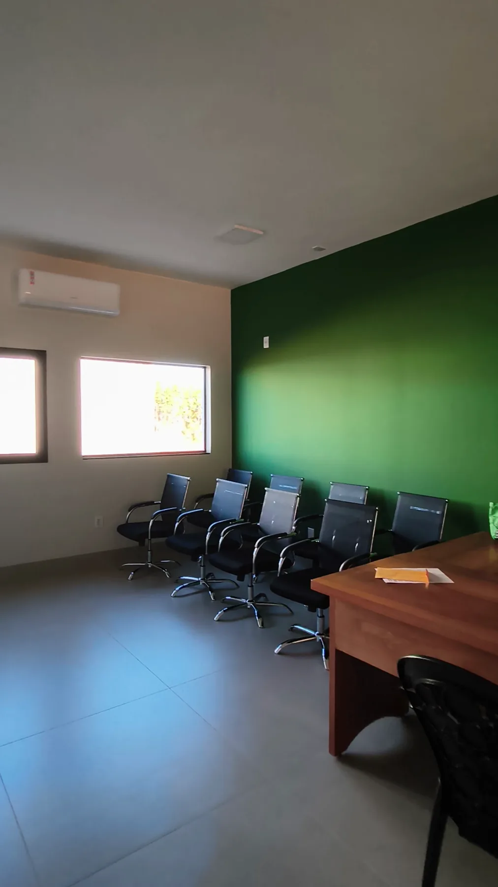 Sala de atendimento do escritório, com mesa e cadeiras para reunião