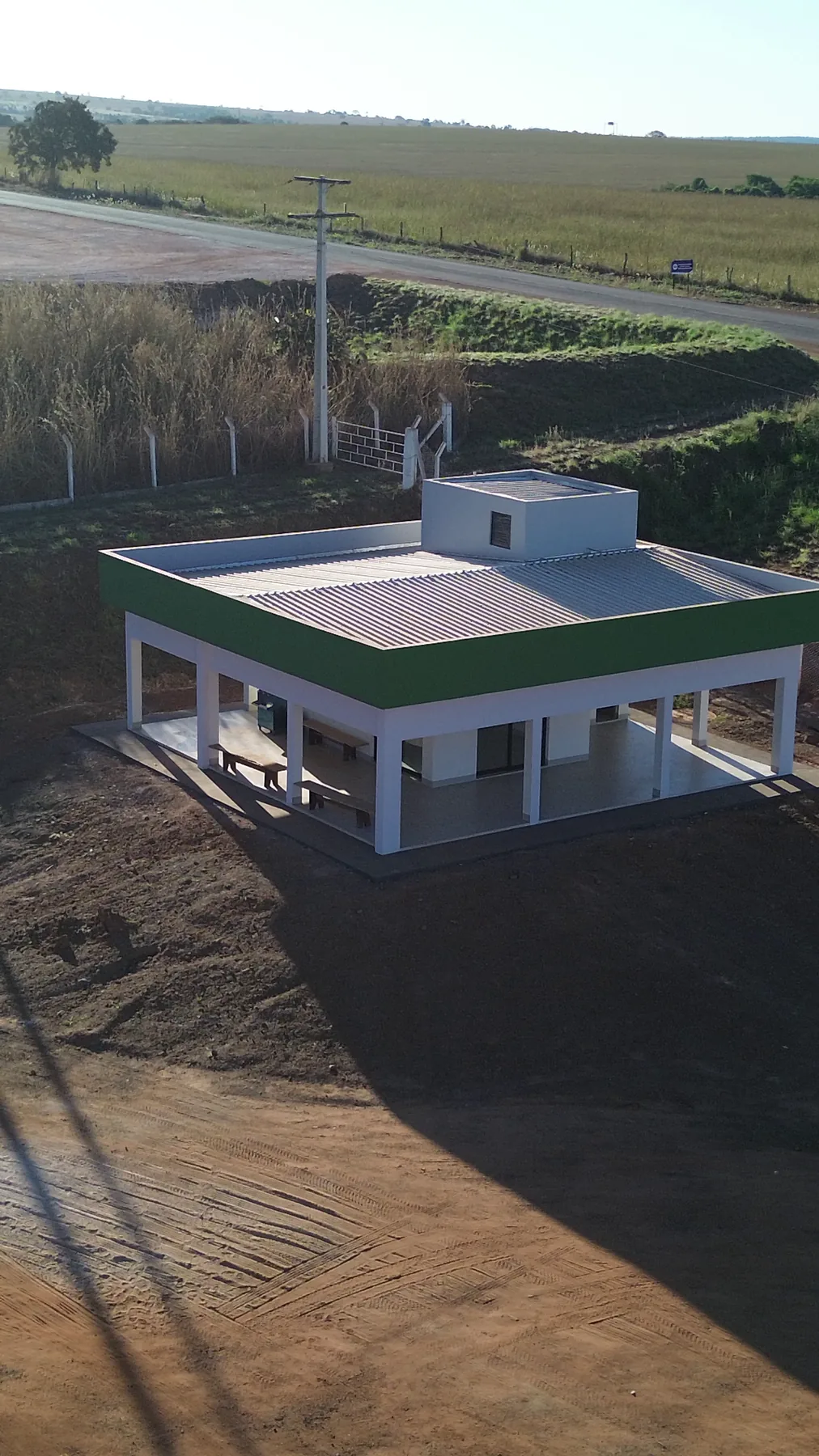 Vista aérea do prédio de apoio com pátio e acesso pela rodovia