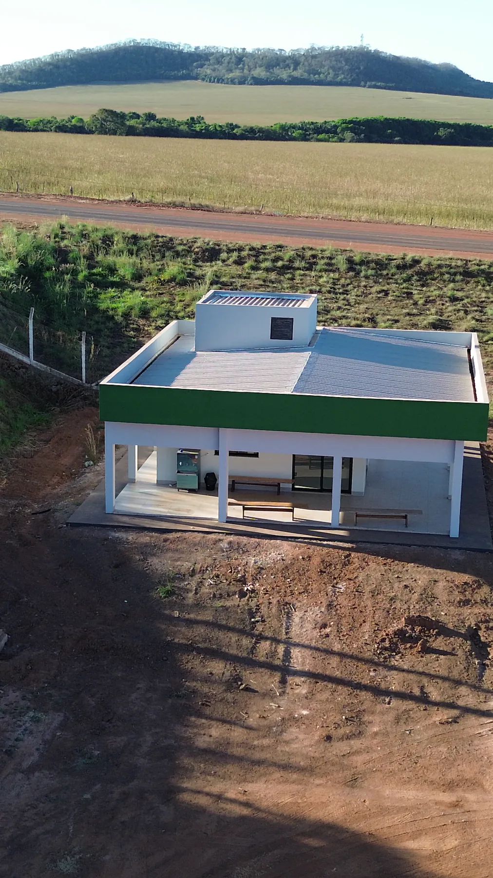 Prédio de apoio visto de cima, com área de convivência e bancos sob a varanda